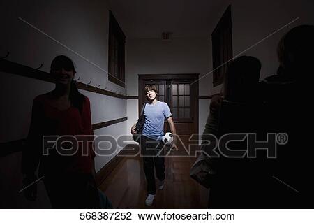 Teenage boy carrying a soccer ball in a school corridor View Large Photo Image Stock Image - Teenage boy carrying a soccer ball in a school corridor. Fotosearch