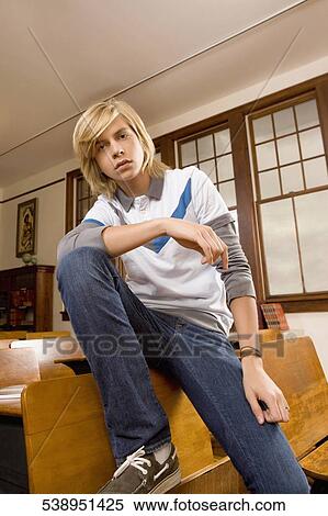 Teenage boy sitting in a classroom and thinking View Large Photo Image Stock Photography - Teenage boy sitting in a classroom and thinking. Fotosearch