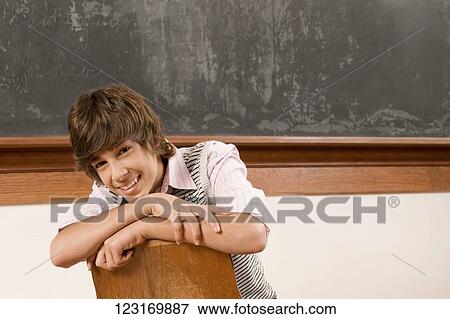 Teenage boy sitting in a classroom View Large Photo Image Stock Photo - Teenage boy sitting in a classroom. Fotosearch