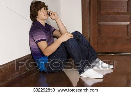 Teenage boy talking on a mobile phone in a school corridor View Large Photo Image Stock Image - Teenage boy talking on a mobile phone in a school corridor. Fotosearch