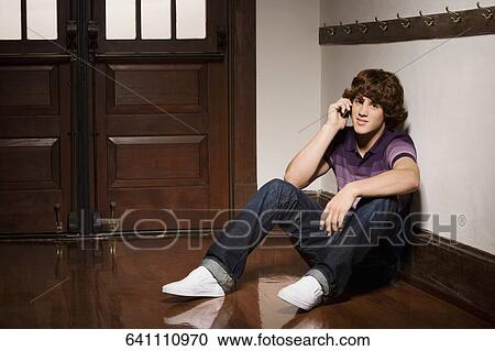 Teenage boy talking on a mobile phone in a school corridor View Large Photo Image Stock Image - Teenage boy talking on a mobile phone in a school corridor. Fotosearch