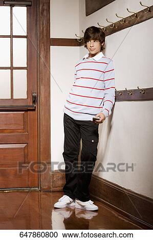 Stock Image - Teenage boy text messaging on a mobile phone. Fotosearch