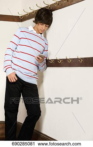 Teenage boy text messaging on a mobile phone View Large Photo Image Stock Image - Teenage boy text messaging on a mobile phone. Fotosearch