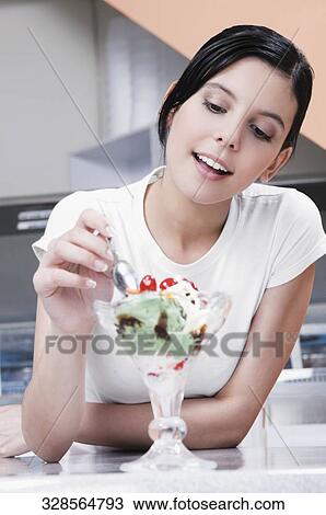 Teenage girl eating an ice cream in an ice cream parlor View Large Photo Image Stock Image - Teenage girl eating an ice cream in an ice cream parlor. Fotosearch