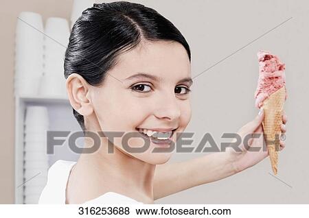 Stock Photo - Teenage girl holding an ice cream. Fotosearch