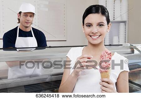 Stock Photo - Teenage girl holding an ice cream. Fotosearch