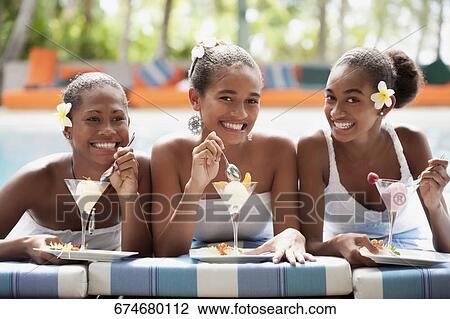 Teenage girl with her friends eating ice creams at the poolside View Large Photo Image Stock Image - Teenage girl with her friends eating ice creams at the poolside. Fotosearch