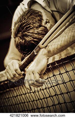 Tennis player leaning over a tennis net View Large Photo Image Stock Photograph - Tennis player leaning over a tennis net. Fotosearch