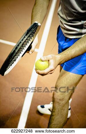 Tennis player playing tennis in a court View Large Photo Image Stock Photo - Tennis player playing tennis in a court. Fotosearch
