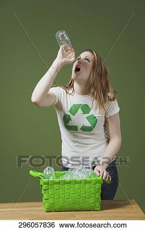 Stock Photograph - Thirsty woman trying to drink water from an empty water bottle. Fotosearch