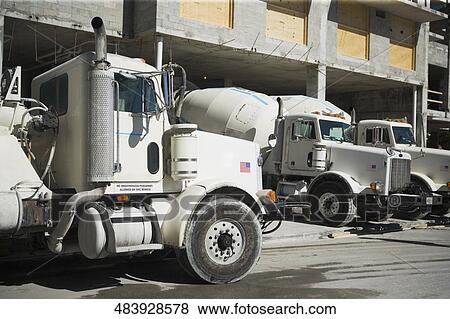 Stock Photo - Three cement trucks at a construction site. Fotosearch