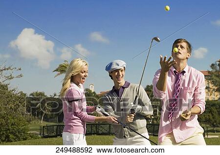 Stock Image - Three friends having fun in a golf course, Biltmore Golf Course, Coral Gables, Florida, USA. Fotosearch