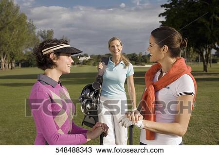 Stock Image - Three golfers in a golf course and smiling, Biltmore Golf Course, Coral Gables, Florida, USA. Fotosearch