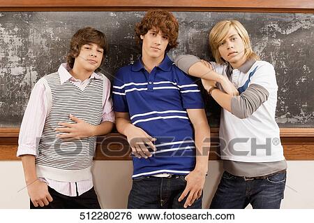 Three students leaning against a blackboard View Large Photo Image Stock Photograph - Three students leaning against a blackboard. Fotosearch