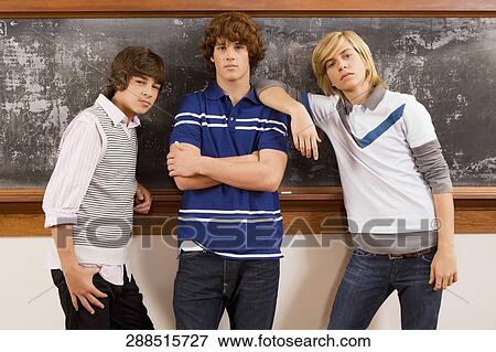 Three students standing in front of a blackboard View Large Photo Image Stock Photo - Three students standing in front of a blackboard. Fotosearch
