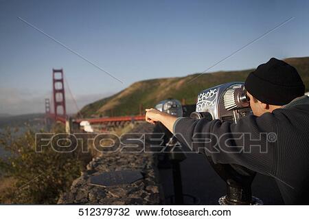 Stock Image - Tourist looking at a bridge through coin-operated binoculars, Golden Gate Bridge, San Francisco Bay, San Francisco, California, USA. Fotosearch