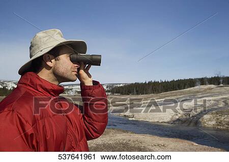 Tourist looking through binoculars, Yellowstone National Park, USA View Large Photo Image Stock Image - Tourist looking through binoculars, Yellowstone National Park, USA. Fotosearch