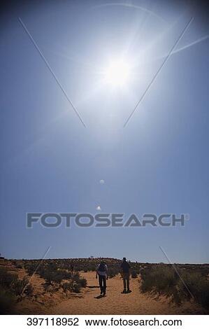 Stock Image - Tourist walking in a desert, Horseshoe Bend, Page, Arizona, USA. Fotosearch