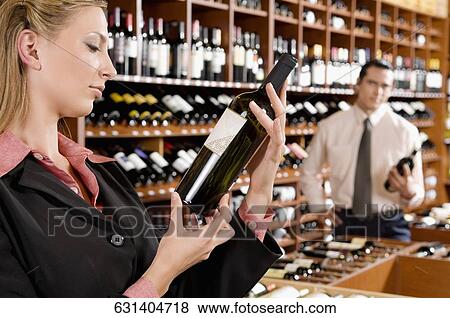 Two business executives holding wine bottles in a bar View Large Photo Image Stock Photo - Two business executives holding wine bottles in a bar. Fotosearch