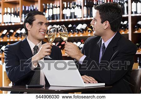 Two businessmen toasting with wine in a bar View Large Photo Image Stock Image - Two businessmen toasting with wine in a bar. Fotosearch