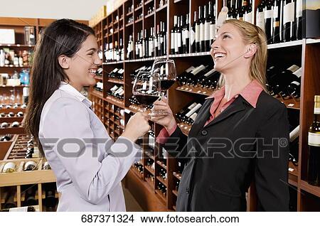 Two businesswomen toasting with wine in a bar View Large Photo Image Picture - Two businesswomen toasting with wine in a bar. Fotosearch