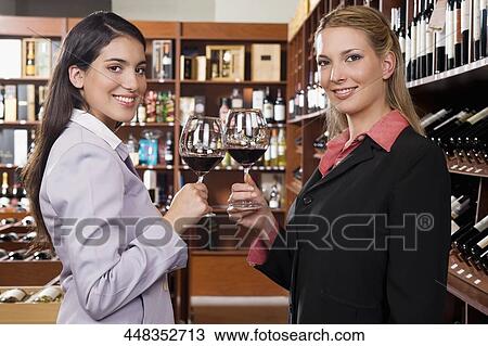 Two businesswomen toasting with wine in a bar View Large Photo Image Stock Image - Two businesswomen toasting with wine in a bar. Fotosearch