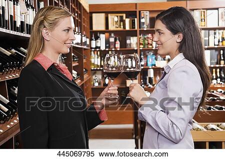 Two businesswomen toasting with wine in a bar View Large Photo Image Stock Photography - Two businesswomen toasting with wine in a bar. Fotosearch