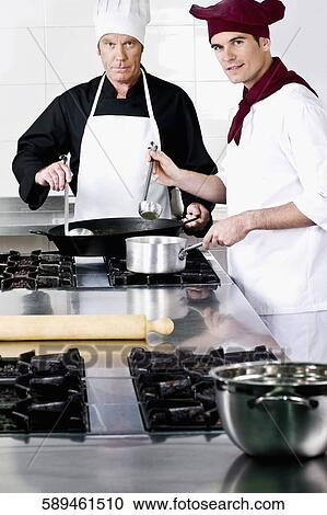 Two chefs cooking food in the kitchen View Large Photo Image Stock Image - Two chefs cooking food in the kitchen. Fotosearch