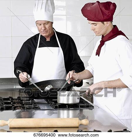 Two chefs cooking food in the kitchen View Large Photo Image Stock Image - Two chefs cooking food in the kitchen. Fotosearch