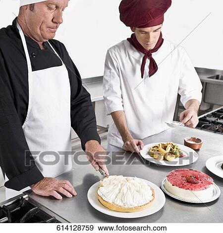 Stock Photo - Two chefs cooking food in the kitchen. Fotosearch