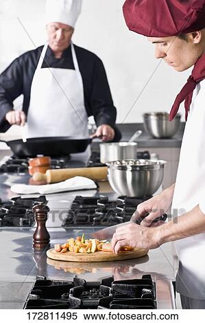 Two chefs cooking food in the kitchen View Large Photo Image Stock Photography - Two chefs cooking food in the kitchen. Fotosearch