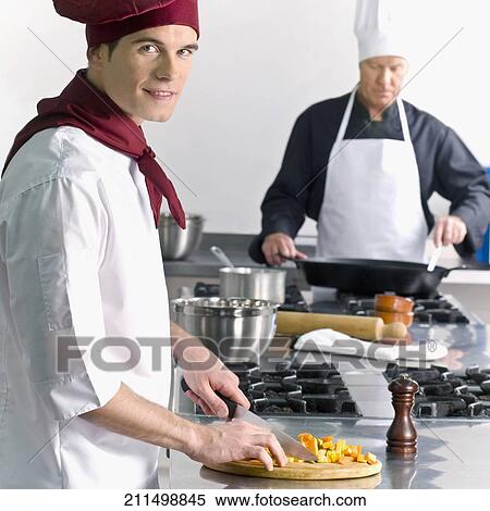 Stock Photography - Two chefs cooking food in the kitchen. Fotosearch