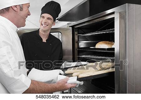 Two chefs preparing food in the kitchen View Large Photo Image Stock Image - Two chefs preparing food in the kitchen. Fotosearch