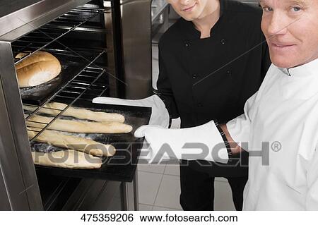 Two chefs preparing food in the kitchen View Large Photo Image Stock Photograph - Two chefs preparing food in the kitchen. Fotosearch