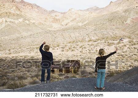 Stock Image - Two children standing on a rock. Fotosearch
