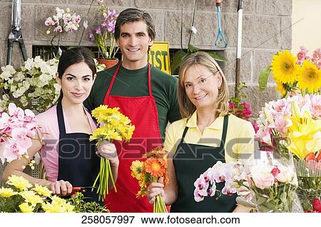 Two female florists with a male florist smiling View Large Photo Image Stock Photo - Two female florists with a male florist smiling. Fotosearch