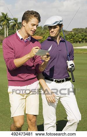 Stock Image - Two friends discussing in a golf course, Biltmore Golf Course, Coral Gables, Florida, USA. Fotosearch