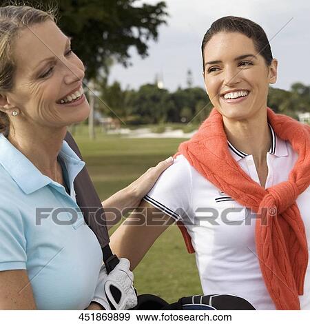 Stock Photo - Two golfers standing in a golf course and smiling, Biltmore Golf Course, Coral Gables, Florida, USA. Fotosearch