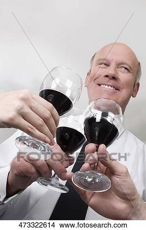 Two men and a woman toasting with wine View Large Photo Image Picture - Two men and a woman toasting with wine. Fotosearch