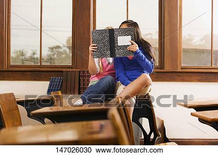 Two schoolgirls reading a book in a classroom View Large Photo Image Stock Image - Two schoolgirls reading a book in a classroom. Fotosearch