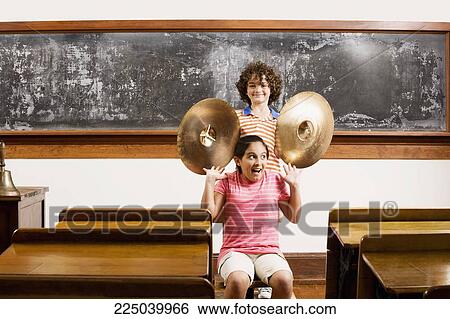 Two students having fun with cymbal in a classroom View Large Photo Image Stock Photograph - Two students having fun with cymbal in a classroom. Fotosearch
