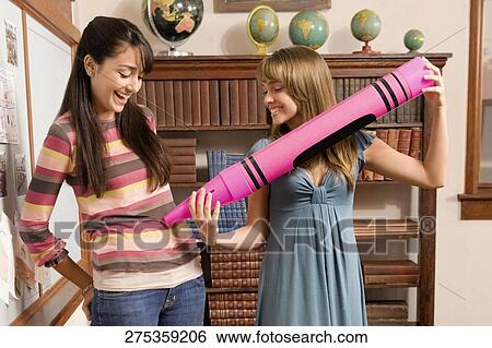 Two students playing in a school library View Large Photo Image Stock Photograph - Two students playing in a school library. Fotosearch