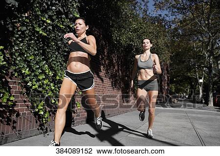 Two women jogging in a street View Large Photo Image Stock Image - Two women jogging in a street. Fotosearch