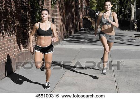 Stock Photograph - Two women jogging in a street. Fotosearch