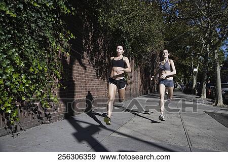 Two women jogging in the street View Large Photo Image Stock Photo - Two women jogging in the street. Fotosearch