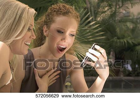 Two women looking at a mobile phone, Biltmore Hotel, Coral Gables, Florida, USA View Large Photo Image Stock Photo - Two women looking at a mobile phone, Biltmore Hotel, Coral Gables, Florida, USA. Fotosearch