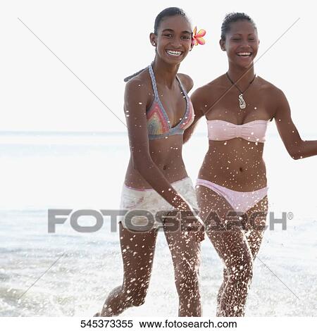 Two women running in water View Large Photo Image Stock Photography - Two women running in water. Fotosearch