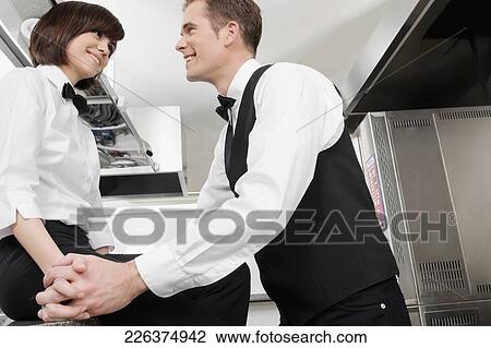 Waiter and waitress romancing in the kitchen View Large Photo Image Stock Image - Waiter and waitress romancing in the kitchen. Fotosearch
