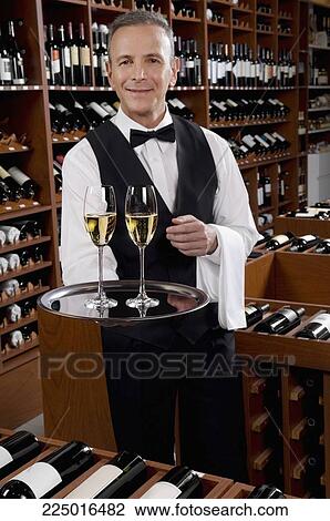 Stock Image - Waiter holding a tray of champagne flutes. Fotosearch