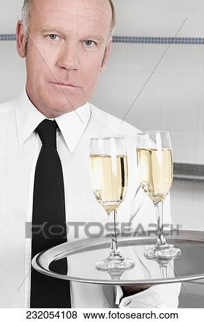Stock Photo - Waiter holding a tray of champagne flutes. Fotosearch